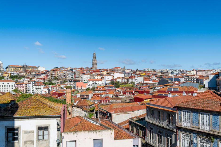 Captivating aerial view of Porto's historic architecture and vibrant red rooftops against a clear blue sky.