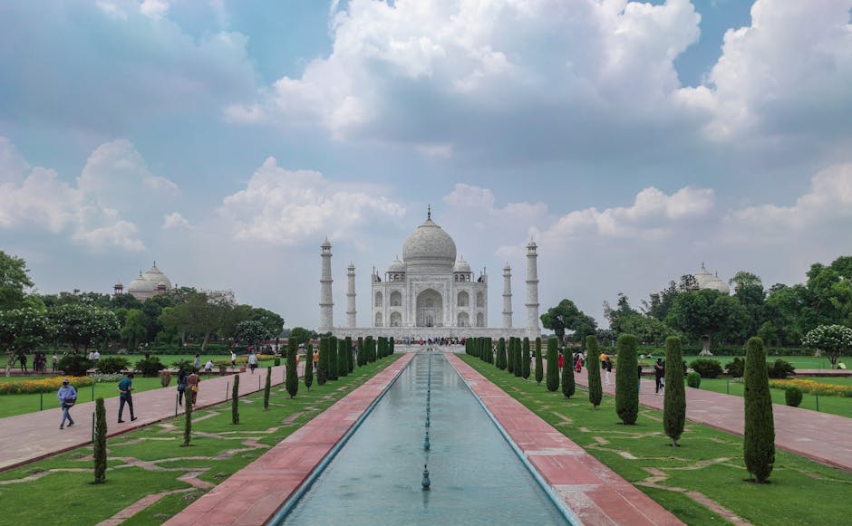 Captivating view of the Taj Mahal with gardens and tourists on a clear day.