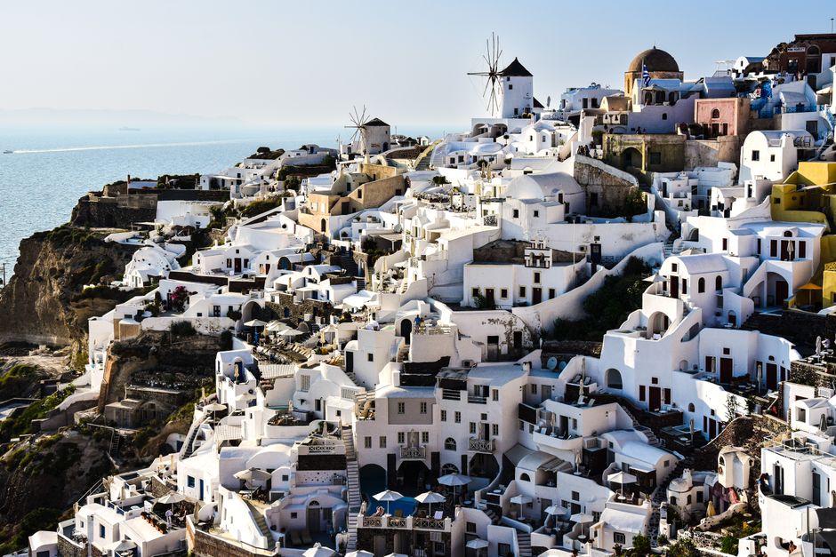 A breathtaking aerial shot of Santorini's iconic white-washed architecture overlooking the Aegean Sea.