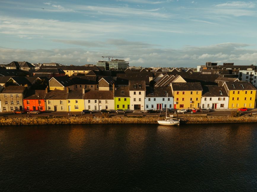 Aerial view of colorful houses along a river in Galway, Ireland at daytime.