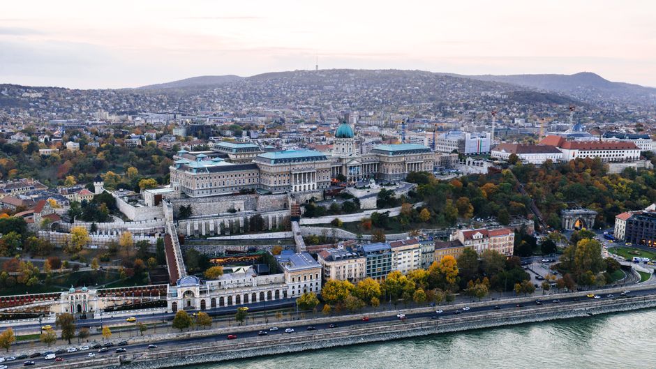 Stunning aerial view of Buda Castle with autumn colors in Budapest, Hungary, captured at dusk.