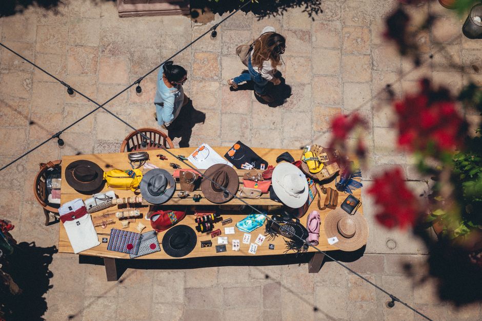 Aerial photo of people browsing a table of hats and accessories in San Miguel de Allende.