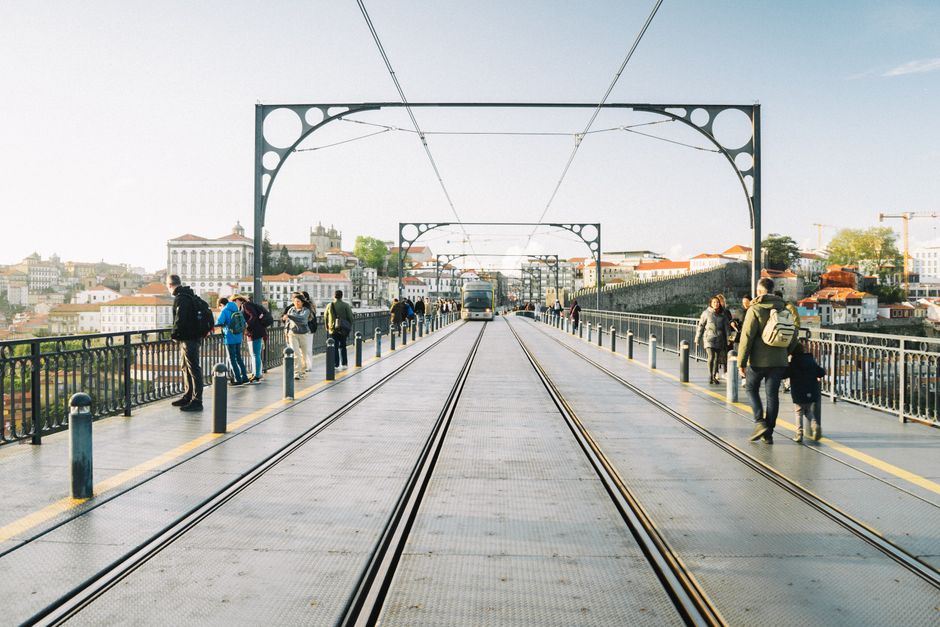View of Dom Luís I Bridge in Porto, Portugal, showing people walking and enjoying the landmark.