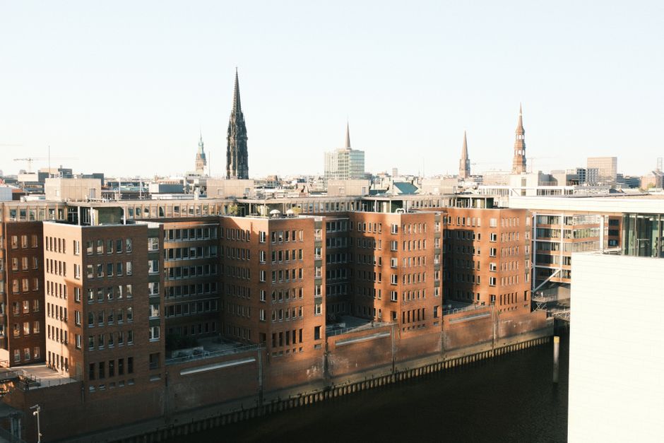 Aerial view of Hamburg's iconic architecture including the St. Nicholas Church spire on a clear day.