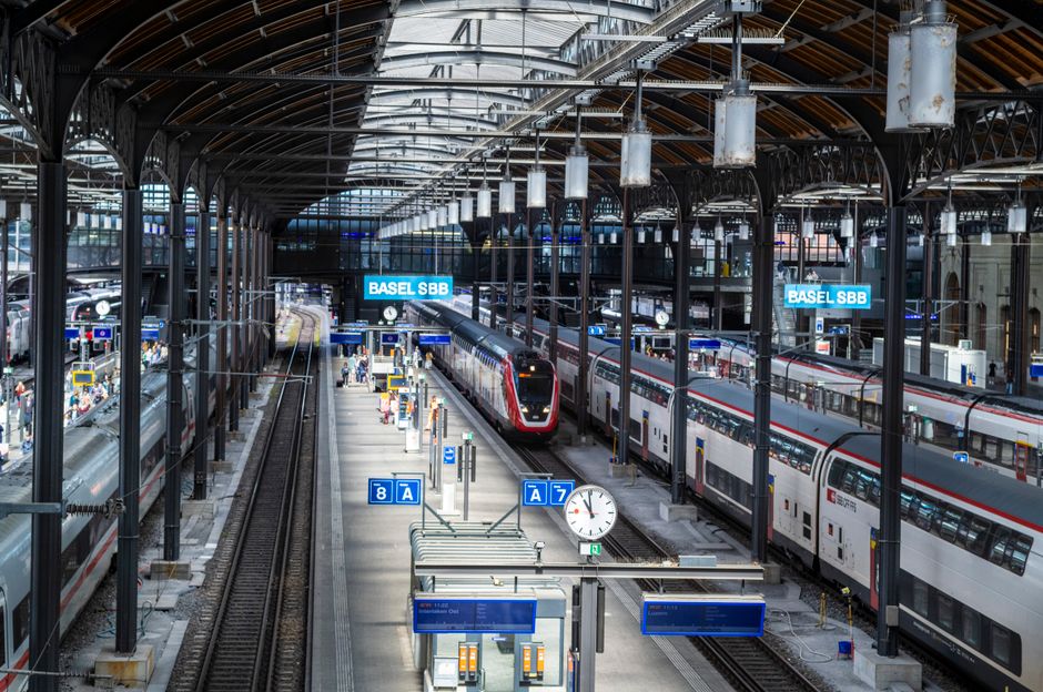 A vibrant view of Basel SBB train station with multiple trains and platforms in Switzerland.