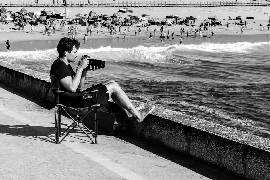 Black and white photo of a photographer capturing beach scenes in Aveiro, Portugal.