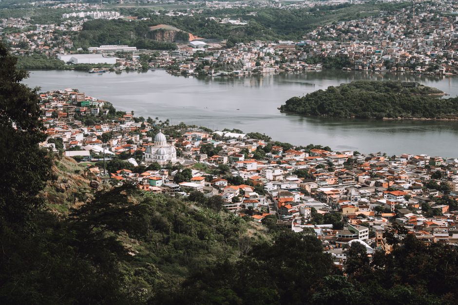 A breathtaking aerial shot of a city with a prominent dome building by a river, surrounded by lush greenery.