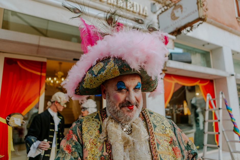 A vibrant carnival costume with ornate details and bright feathers captured outdoors, embodying festive elegance.